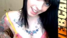 Preciosa morena tatuada dándose cariño frente a su webcam