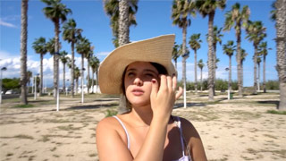 Lara Fox pasea por la playa con su sombrero de verano